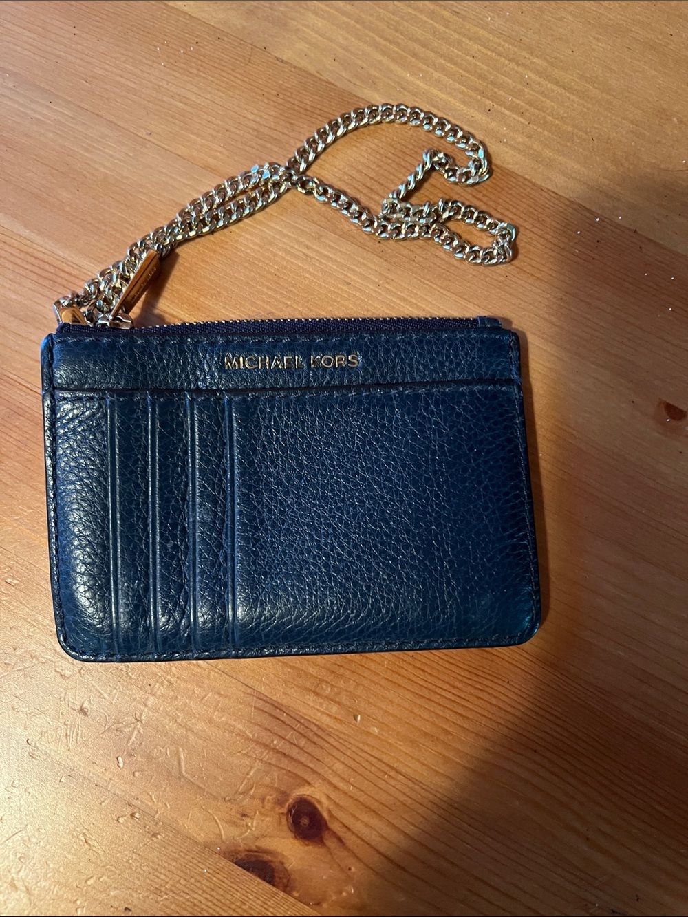 Michael Kors Wristlet with a gold detachment chain.